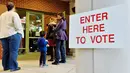 Warga mengajak anaknya saat akan melakukan pemilihan presiden AS di Durham, North Carolina, AS, Selasa (8/11). Warga AS akan menentukan presiden mereka antara Hillary Clinton dan Donald Trump. (AFP Photo/ Sara D. Davis)