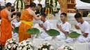 Biksu mencukur rambut anak-anak, yang diselamatkan dari gua di Thailand, pada upacara pentahbisan di Kuil Wat Phra That Doi Wao, Chiang Rai, Selasa (24/7). 11 dari 12 remaja itu menjalani ritual menjadi biksu. (Panumas Sanguanwong/THAI NEWS PIX/AFP)