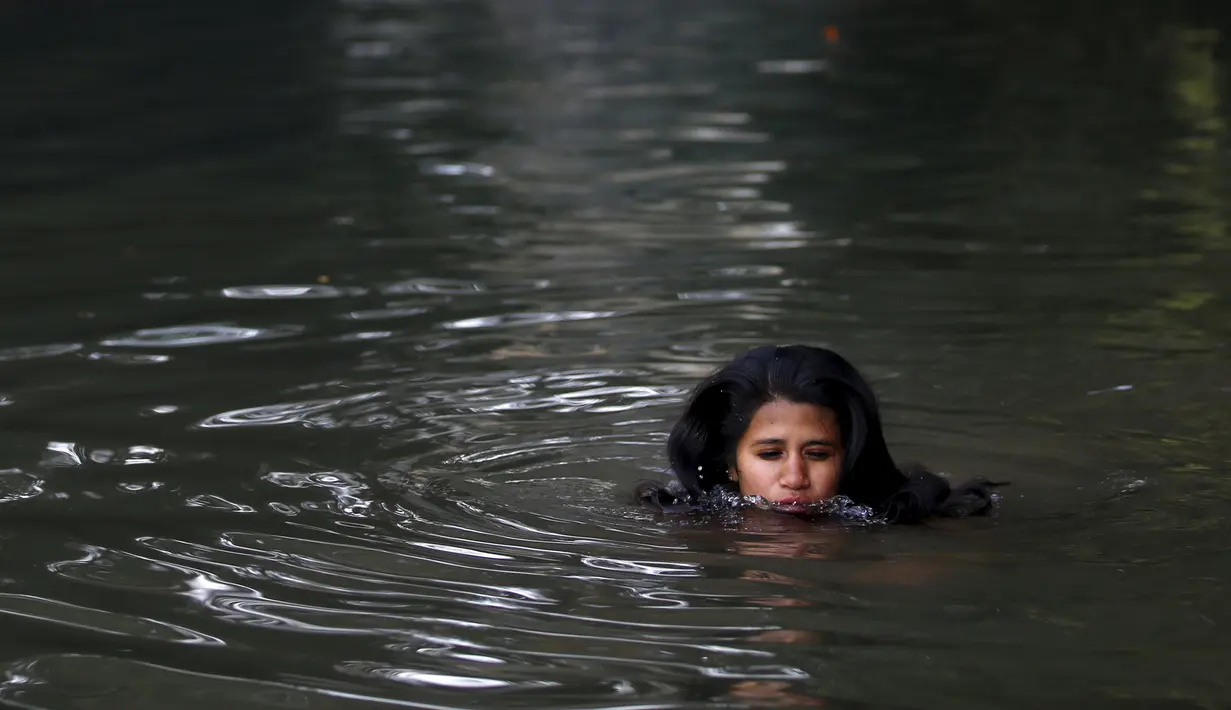 Wanita Hindu Nepal mandi suci disungai Salinadi saat Festival Swasthani Brata Katha di Katmandu, Nepal, (24/1). Selama festival umat Hindu Nepal membaca kitab suci Hindu yang didedikasikan untuk dewi Swasthani dan Dewa Siwa. (REUTERS/Navesh Chitrakar)
