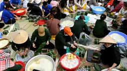 Orang-orang menyiapkan "Banh Chung" atau kue beras tradisional Vietnam untuk amal, menjelang Tahun Baru Imlek atau festival Tet di Pagoda Tam Chuc di provinsi Ha Nam (7/1/2023). Banh Chung adalah kelezatan khas Vietnam yang terbuat dari ketan, daging babi, dan kacang hijau yang dibungkus dengan daun pisang dan dimasak selama 10 jam. (AFP/Nhac Nguyen)