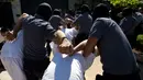 Petugas kepolisian menggelandang anggota geng Mara Salvatrucha di Zacatecoluca, El Salvador (31/1). Mara Salvatrucha merupakan geng kriminal yang berasal dari Los Angeles, AS yang telah menyebar ke Amerika Tengah dan Kanada. (AP Photo/Moises Castillo)