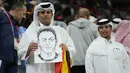 Seorang penonton memegang sketsa mantan pesepakbola Jerman Mesut Ozil pada akhir pertandingan Spanyol vs Jerman saat laga Grup E Piala Dunia 2022  di Stadion Al Bayt, Kota Al Khor pada Senin (28/11/2022) dini hari WIB. Perlu diketahui bahwa Mesut Ozil mundur dari karier timnasnya tidak lama setelah hasil mengecewakan Jerman di babak penyisihan grup di Piala Dunia 2018 Rusia. (AP Photo/Julio Cortez)