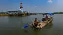 Warga menggunakan perahu  menyaksikan puing-puing bangunan mesjid dan rumah yang kembali muncul di kawasan Bendungan Karian yang mengering di Kampung Somang, Lebak, Banten, Jumat, 7 Agustus 2026. (KLY/ Arie Basuki)