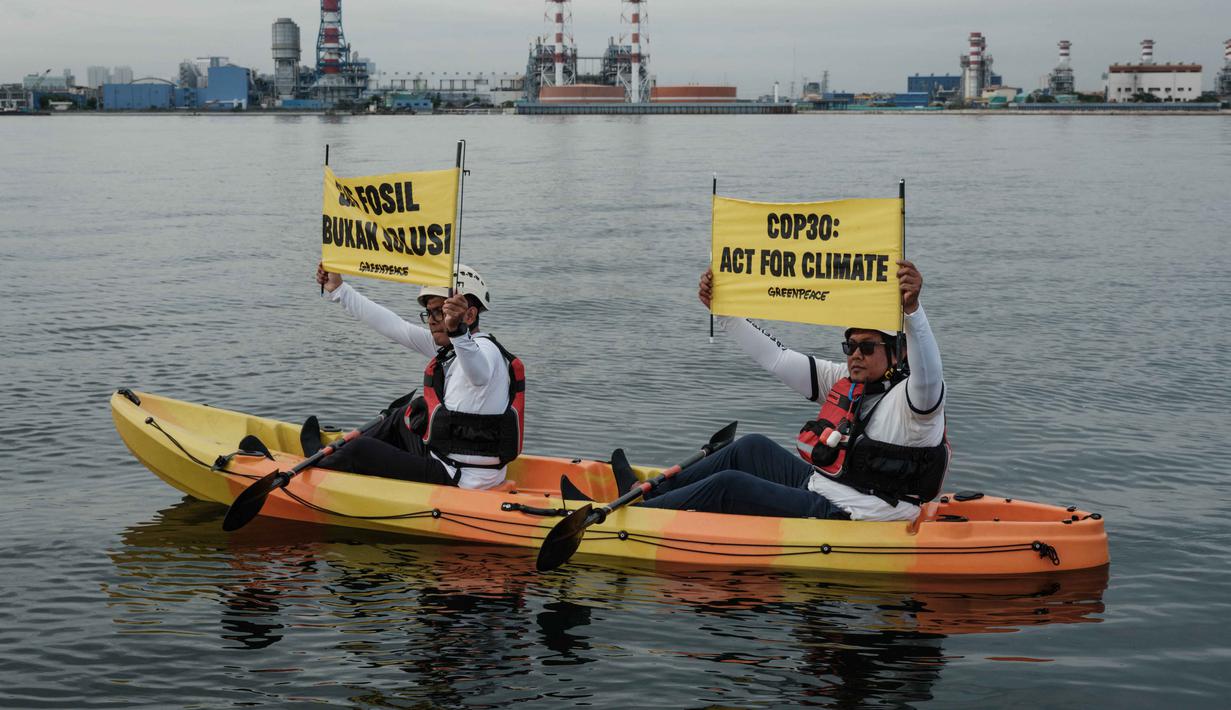 Saat aksi, para aktivis membentangkan spanduk untuk menyoroti inkonsistensi kebijakan energi nasional yang masih mengandalkan bahan bakar fosil, termasuk gas, sebagai solusi transisi energi. Tampak dalam foto, aktivis Greenpeace Indonesia melakukan aksi di kawasan perairan depan Pembangkit Listrik Tenaga Gas Uap (PLTGU) Muara Karang, Jakarta pada Selasa 18 November 2025. (YASUYOSHI CHIBA/AFP)