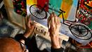 Seniman becak, Hanif Pappu sedang mengerjakan sebuah lukisan di tokonya di Dhaka. (Munir UZ ZAMAN/AFP)