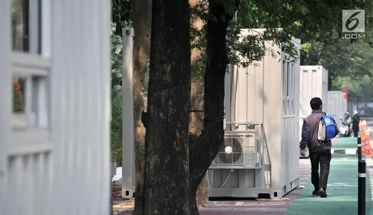 Pengendara sepeda melintas di depan kontainer tiket Asian Games 2018 yang berdiri di sepanjang trotoar Jalan Pintu 1 Senayan, Jakarta, Selasa (7/8). (Merdeka.com/Iqbal Nugroho)