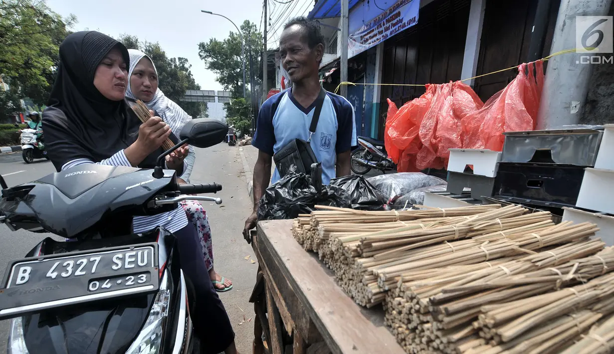 Penjual arang, tusuk sate, dan kotak pemanggang melayani pembeli di kawasan Manggarai, Jakarta, Rabu (22/8). Perlengkapan membuat sate dijual mulai dari Rp 5.000 hingga Rp 120.000. (Merdeka.com/Iqbal Nugroho)