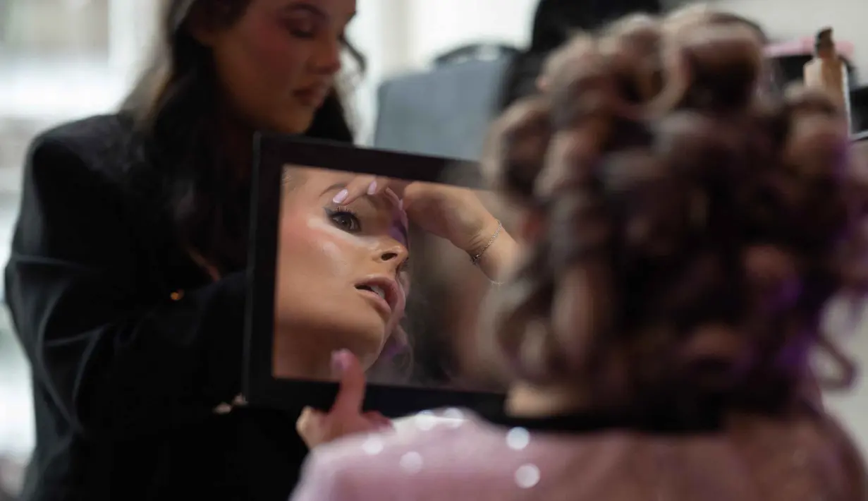 Kontes ini pertama kali diadakan pada musim panas 1945, setelah Perang Dunia II, di Morecambe, Lancashire. Tampak dalam foto, Ava Morgan, Miss Great Britain 2024/25, mempersiapkan riasannya sebelum mengikuti babak final Miss Great Britain 2025/26 yang diadakan di venue Athena, Leicester, Inggris, pada Jumat 17 Oktober 2025. (Oli SCARFF/AFP)