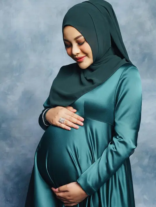 Dipadukan kerudung dengan warna hijau yang lebih gelap. Tampak ia pun mengenakan perhiasaan silvernya. [@aurelie.hermansyah]