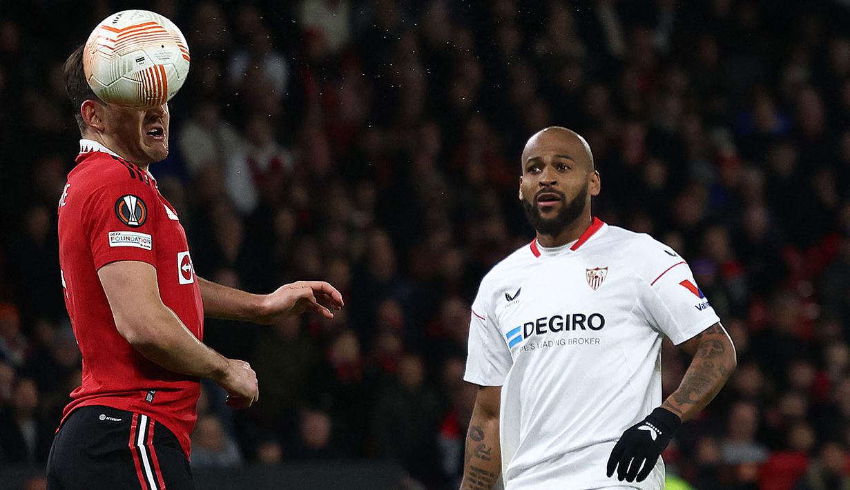 <p>Pemain Manchester United, Harry Maguire (kiri) mencetak gol bunuh diri pada laga leg pertama perempat final Liga Europa 2022/2023 melawan Sevilla di Old Trafford, Manchester, Jumat (14/04/2023) dini hari WIB. Laga berakhir dengan skor 2-2. (AFP/Darren Staples)</p>
