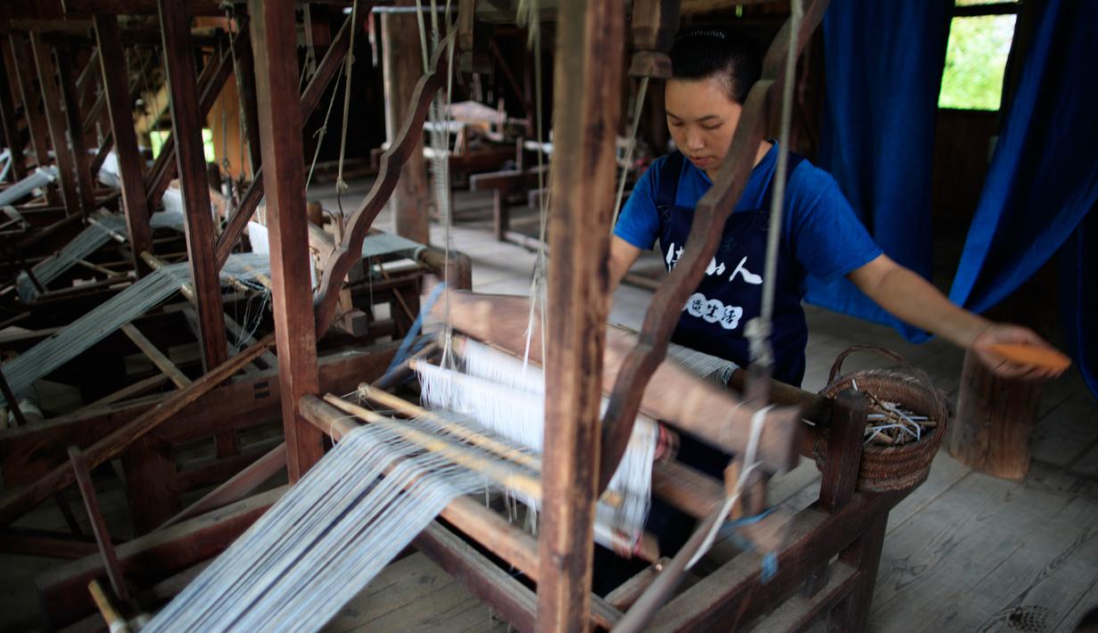 Seorang perempuan menenun kain di sebuah bengkel kerja di Desa Etnis Dong Fengdeng di Wilayah Rongjiang, Provinsi Guizhou, China pada 6 September 2020. Warga setempat memanfaatkan kondisi cuaca musim gugur yang mendukung untuk membuat kain tradisional kelompok etnis Dong. (Xinhua/Liu Xu)