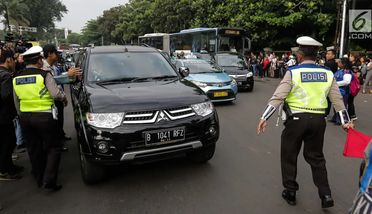 Petugas polisi lalu lintas memberi arahan kepada pengguna mobil saat pemberlakuan sistem ganjil genap di pintu masuk Gardu Tol Cibubur 2, Jakarta, Senin (16/4). (Liputan6.com/Faizal Fanani)