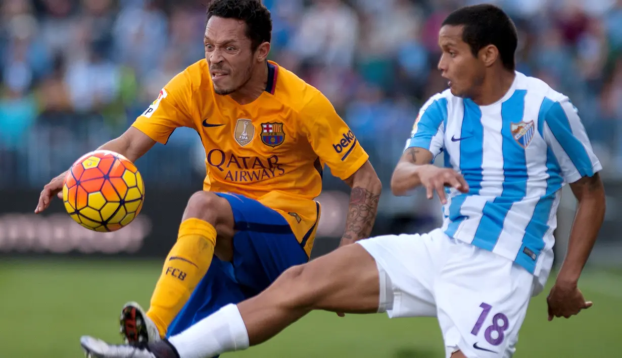 Pemain Barcelona, Adriano (kiri), berebut bola dengan pemain Malaga, Roberto Jose Rosales, dalam laga La Liga Spanyol di Stadion La Rosaleda, Malaga, Sabtu (23/1/2016). (AFP/Jorge Guerrero)