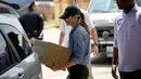 Ibu negara AS, Melania Trump membawa barang untuk disumbangkan kepada korban Badai Harvey saat berkunjung ke First Church, Pearland, Texas (2/9).  Melania tampil kasual dengan mengenakan kemeja jeans dan sepatu sneakers. (Win McNamee/Getty Images/AFP)