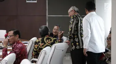 Menko Perekonomian Darmin Nasution berbincang saat mengunggu Rakor Tingkat Menteri di Kantor Kemenko PMK, Jakarta, Rabu (6/11). Rakor tersebut membahas tentang Evaluasi Pelaksanaan Program Rastra dan BPNT tahun 2017. (Liputan6.com/Faizal Fanani)