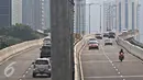 Pengendara sepeda motor melintas di jalan layang non-tol Kampung Melayu-Tanah Abang, Jakarta, Jumat (15/4). Meski berbahaya bagi keselamatan mereka dan pengguna jalan lain, pemotor tetap melintas di jalur tersebut. (Liputan6.com/Immanuel Antonius)