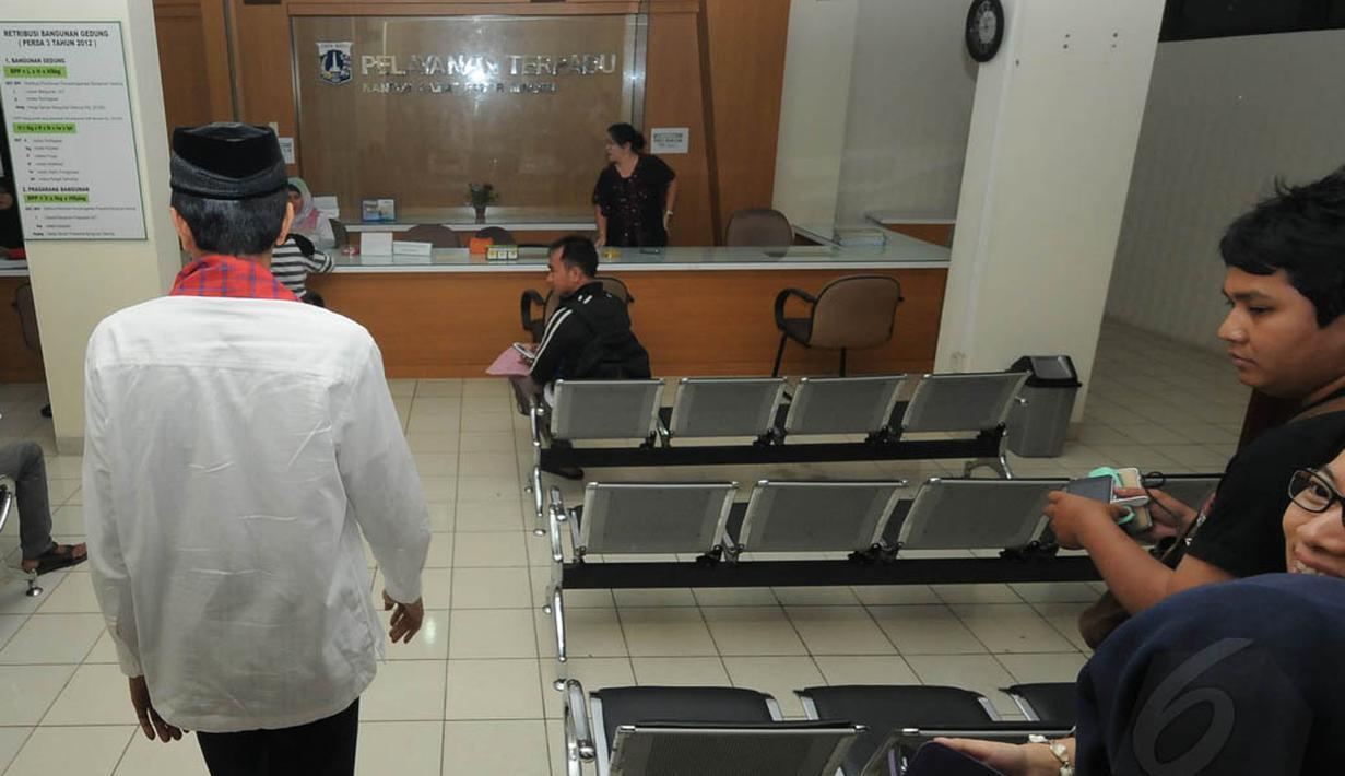 Jokowi yang mengenakan baju koko putih dan sarung merah yang dikalungkan di leher, datang sekitar pukul 11.00 WIB dan langsung masuk ke ruang tunggu kantor Kecamatan Pasar Minggu, Jakarta, Jumat (23/5/14). (Liputan6.com/Herman Zakharia)