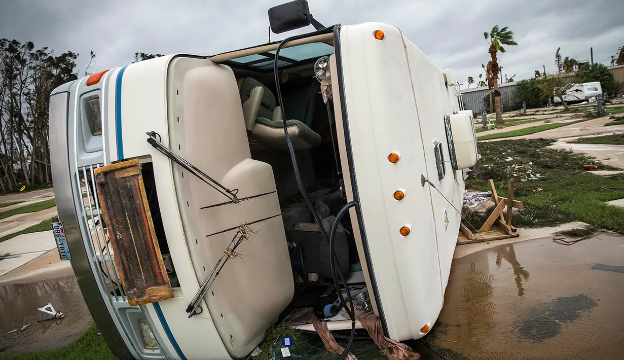 Sebuah mobil rumah atau RV hancur akibat terjangan Badai Harvey di Port Aransas, Texas, Minggu (27/8). Pemerintah sendiri telah mengerahkan puluhan kapal dan 5 helikopter penyelamat serta bus untuk mengevakuasi warga ke tempat yang aman. (AP Photo)
