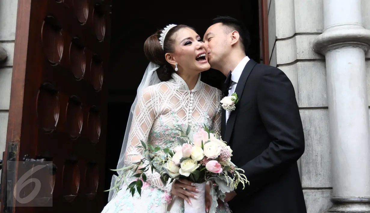 Pasangan Selebritis Olga Lydia dan Aris berpose seusai menjalankan sakramen pernikahan di Gereja Katedral, Jakarta, Jumat (21/4). Aktris Olga Lydia dan Aris Utama menjalankan sakramen pernikahan. (Liputan6.com/Herman Zakharia)