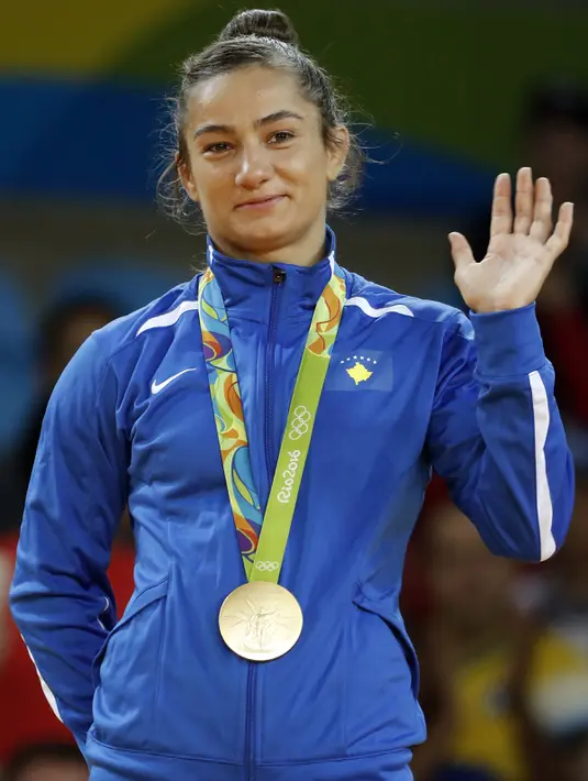 Atlet Kosovo Majlinda melambaikan tangan setelah meraih medali emas pada cabang judo putri di atas podium Olimpiade 2016, Minggu (7/8). Kelmendi yang merupakan peringkat dua di kelas 52kg mengalahkan Odette Giuffrida asal Italia. (Toshifumi Kitamura/AFP)