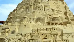 Seorang seniman saat membuat istana pasir di Landschaftspark di Duisburg, Jerman , (1/9). Seniman dari Duisburg burusaha meraih Guinness Book of World Records dengan membuat istana pasir tertinggi yang pernah ada. (Marcel Kusch / dpa via AP)