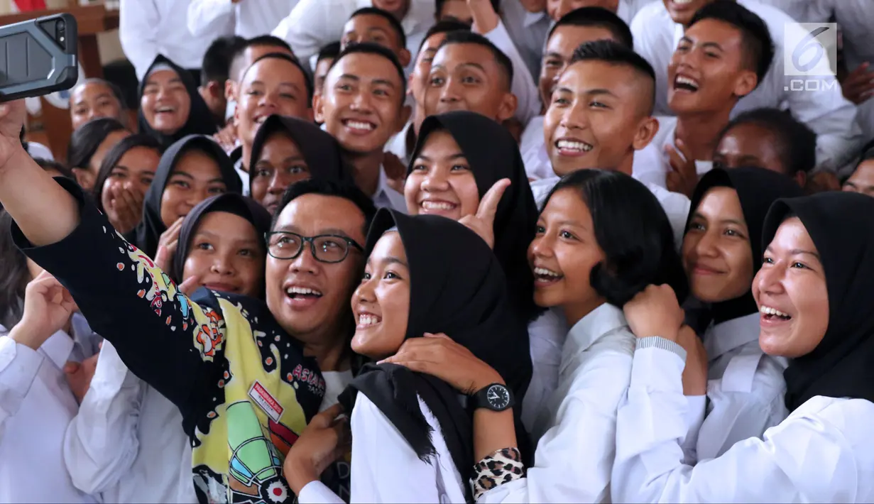 Menpora Imam Nahrawi (tengah) berswafoto bersama peserta Diklat Paskibraka Nasional 2018 di Wisma Soegondo Cibubur, Jakarta, Kamis (26/7). Diklat diikuti 68 siswa terbaik dari 34 provinsi di Indonesia. (Liputan6.com/Helmi Fithriansyah)