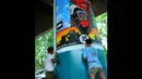 Seorang peserta tengah menyelesaikan lukisan muralnya di Stasiun Gambir, Jakarta, Sabtu (30/8/14). (Liputan6.com/Faisal R Syam) 