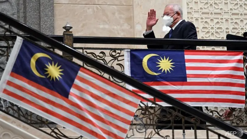 Mantan Perdana Menteri Malaysia Najib Razak melambaikan tangan saat tiba di pengadilan federal di Putrajaya pada 15 Agustus 2022. (Foto: AFP/Mohd Rasfan)