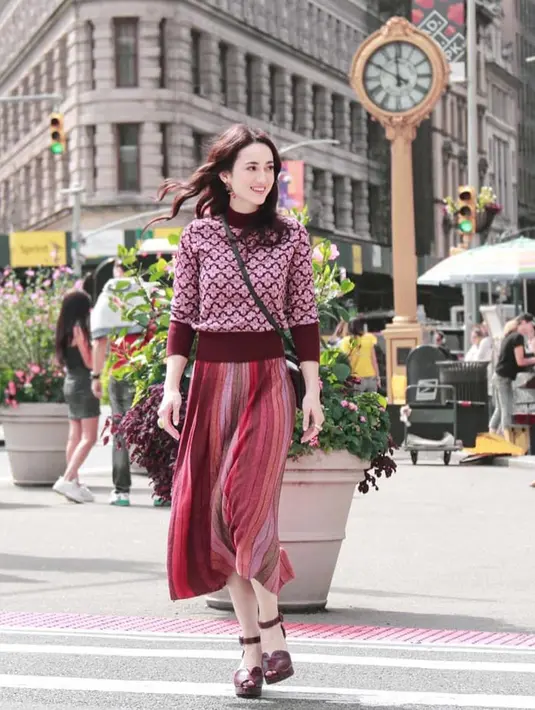 Julie Estelle mengenakan sweater turtleneck bermotif bunga dipadukan dengan rok berwarna merah yang manis dari Kate Spade. (Liputan6.com/IG/@julstelle)