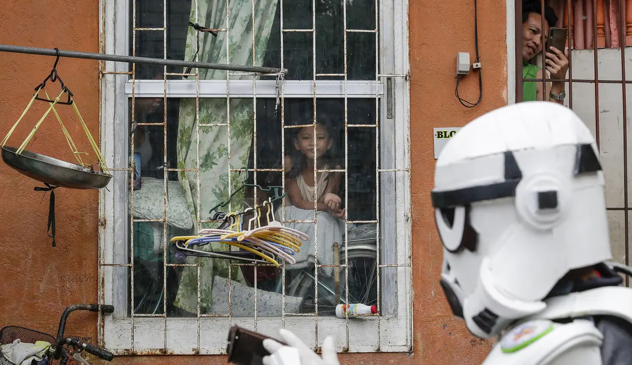 Anggota kelompok pemuda dalam kostum Star Wars menghibur warga di Malabon, Metro Manila, Filipina, Kamis (30/4/2020). Kelompok pemuda berkostum Star Wars menghibur warga selama karantina berkelanjutan akibat COVID-19 serta mengingatkan mereka agar tetap di rumah. (AP Photo/Aaron Favila)