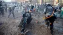 Orang-orang yang bersuka ria mengenakan pakaian militer tiruan saat ikut serta dalam perang makanan "Els Enfarinats" di Kota Ibi, Spanyol, 28 Desember 2022. 
Festival tradisional ini sudah berlangsung selama 200 tahun. (JAIME REINA/AFP)