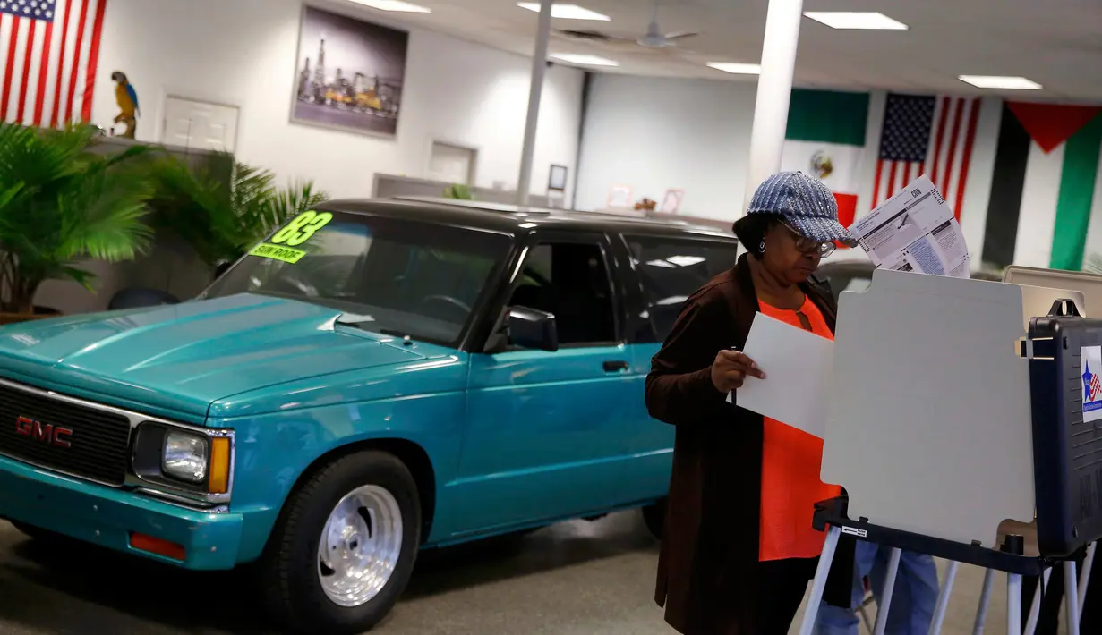 Seorang wanita memberikan suaranya di sebuah showroom mobil, Sam's Auto Sales, yang dijadikan lokasi tempat pemungutan suara (TPS) pemilihan presiden Amerika Serikat (Pilpres AS) di Chicago, Illinois, Selasa (8/11). (REUTERS/Jim Young)