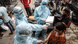 Petugas kesehatan India yang mengenakan alat pelindung diri melakukan pemeriksaan COVID-19 di kawasaan permukiman kumuh di tengah penyebaran wabah tersebut di Mumbai, India (17/6/2020). (Xinhua/Stringer)