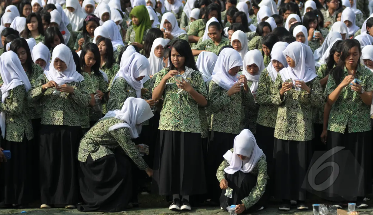 Ribuan pelajar bersiap mengikuti acara minum jamu bersama di Alun-Alun Satya Negara Sukoharjo, Jawa Tengah, Rabu (1/4/2015). Kegiatan tersebut dalam rangka pelestarian jamu ke masyarakat nasional maupun internasional. (Liputan6.com/Johan Tallo)