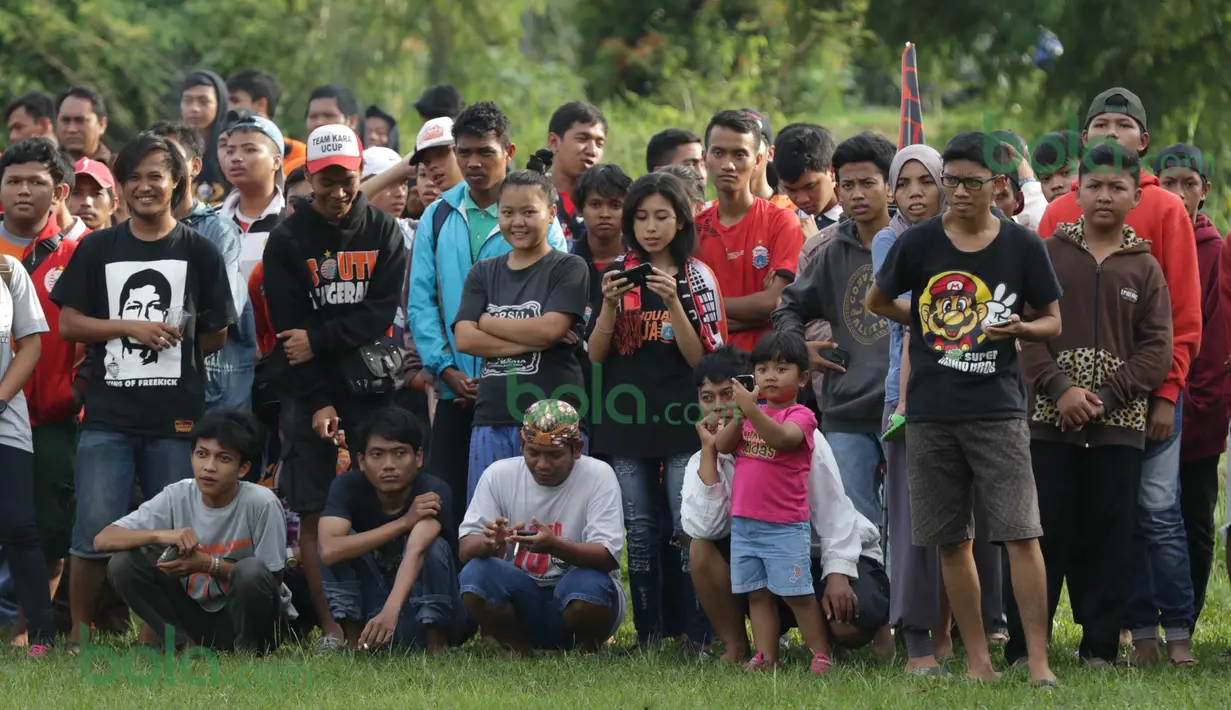 Ratusan Suporter The Jakmania rela berdiri diatas rumput basah untuk menonton tim Persija Jakarta berlatih  di Lapangan Youth Training Center, Sawanngan, Depok, Rabu (17/2/2016). (Bola.com/Nicklas Hanoatubun)