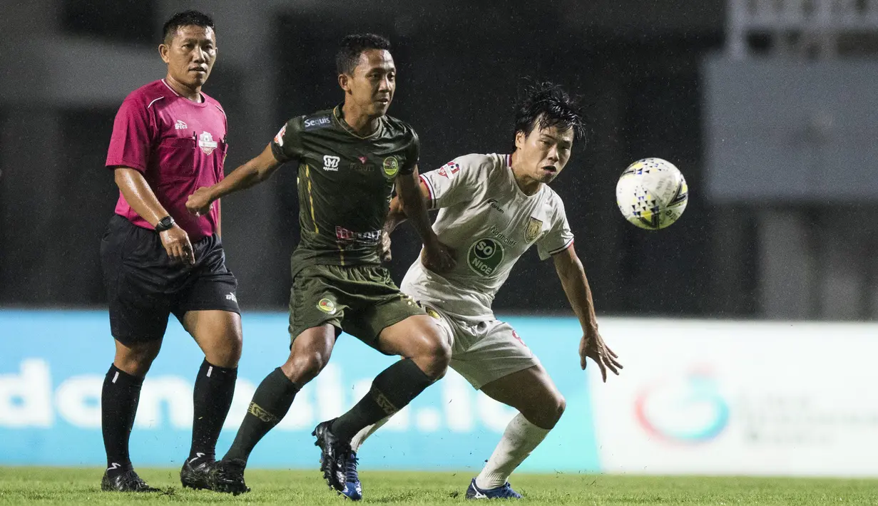Gelandang Tira Persikabo, Roni Sugeng, berebut bola dengan gelandang Persela Lamongan. Kei Hirose, pada laga Liga 1 di Stadion Pakansari, Bogor, Senin (16/12). Kedua klub bermain imbang 1-1. (Bola.com/Vitalis Yogi Trisna)