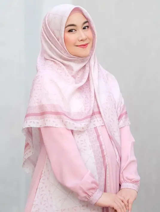 Sementara untuk tampilan feminin, bumil ini memilih gamis warna pink muda dengan motif halus. (Instagram/anisarahma_12).
