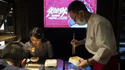 Seorang staf mengemas sisa bahan hot pot untuk para pelanggan restoran di Chengdu, Provinsi Sichuan, China, 7 September 2020. Banyak restoran hot pot di Chengdu menawarkan porsi makanan lebih kecil dan layanan takeaway dalam kampanye yang bertujuan mengurangi limbah makanan. (Xinhua/Li Mengxin)
