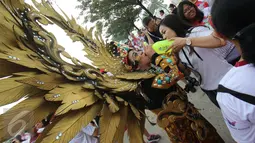 Seorang peserta mengenakan kostum beristirahat sambil meminum air saat mengikuti Joyful Run&Walk 2017 di Alam Sutra, Tangerang, Minggu (7/5). Tema acara ini adalah Joyful Asian Youth! Living the Gospel in Multicultural Asia. (Liputan6.com/Helmi Afandi)