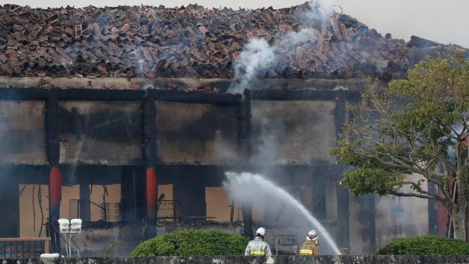 Petugas pemadam kebakaran berusaha memadamkan api yang membakar Kastil Shuri di Okinawa, Jepang selatan, Kamis (31/10/2019). Aula utama kastil yang dibangun dari kayu tersebut dilaporkan hangus tinggal rangka bangunan. (Jun Hirata/Kyodo News via AP)