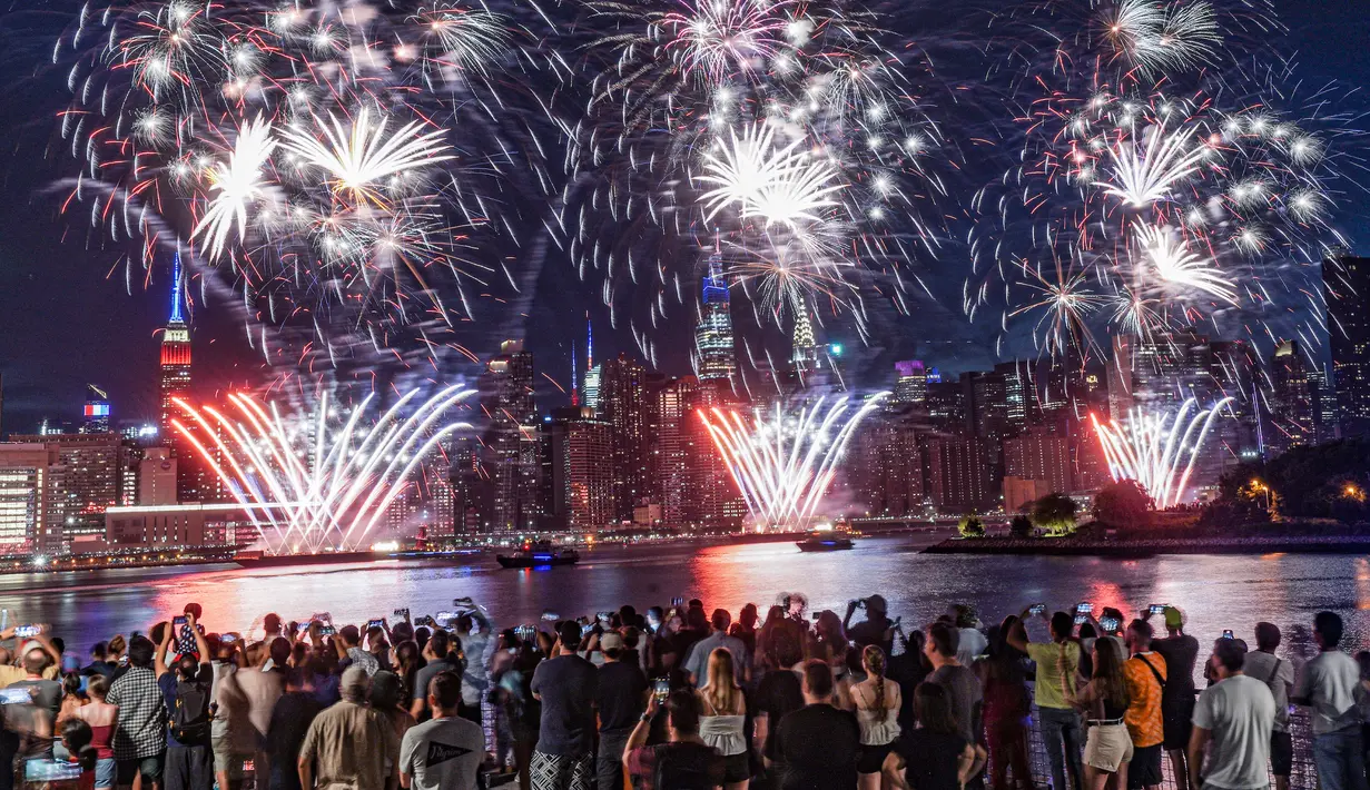 Penonton berkumpul di sepanjang tepi pantai Williamsburg untuk menyaksikan pertunjukan kembang api Macy pada perayaan Hari Kemerdekaan di Brooklyn, New York, Amerika Serikat, 4 Juli 2022. Kembang api meledak dari tongkang di East River. (AP Photo/Bebeto Matthews)