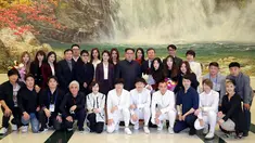 Pemimpin Korea Utara Kim Jong-Un (tengah) dan istrinya Ri Sol-Ju (tengah kiri) berfoto bersama sejumlah bintang K-pop dan musisi dari Korea Selatan di East Pyongyang Grand Theatre, Korea Utara (4/1). (AFP Photo/KCNA)