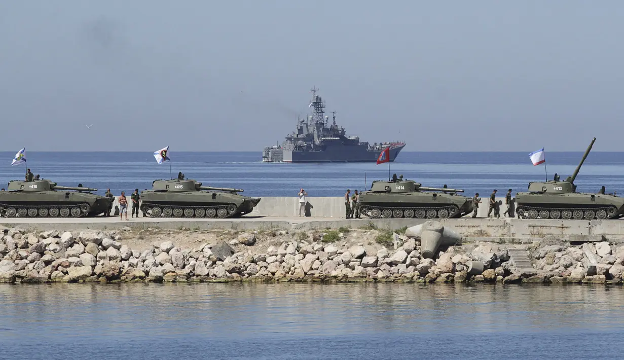 Sejumlah Howitzer self-propelled 2S1 Gvozdika (depan) dan kapal perang Azov terlihat saat latihan untuk memperingati Hari angkatan Laut di Sevastopol, Krimea, Rusia (24/7/2015). (REUTERS/Pavel Rebrov)