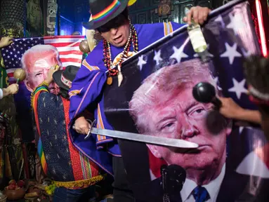 Dukun melakukan ritual mistik dengan memegang gambar Presiden Donald Trump dan pesaingnya dari Demokrat Joe Biden, di Lima, Peru, Rabu (16/9/2020). Para dukun berkumpul untuk memprediksi siapa pemenang dari pemilihan presiden AS yang akan dihelat pada 3 November mendatang. (AP Photo/Rodrigo Abd)