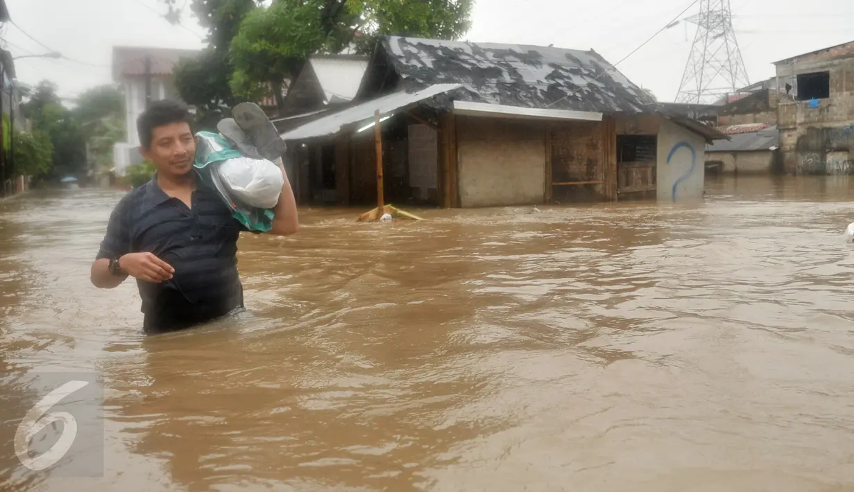 Warga melintasi banjir di kawasan Cipinang Melayu, Jakarta Timur, Senin (20/2). Sebanyak 285 warga diungsikan akibat banjir setinggi 1 meter. (Liputan6.com/Yoppy Renato)