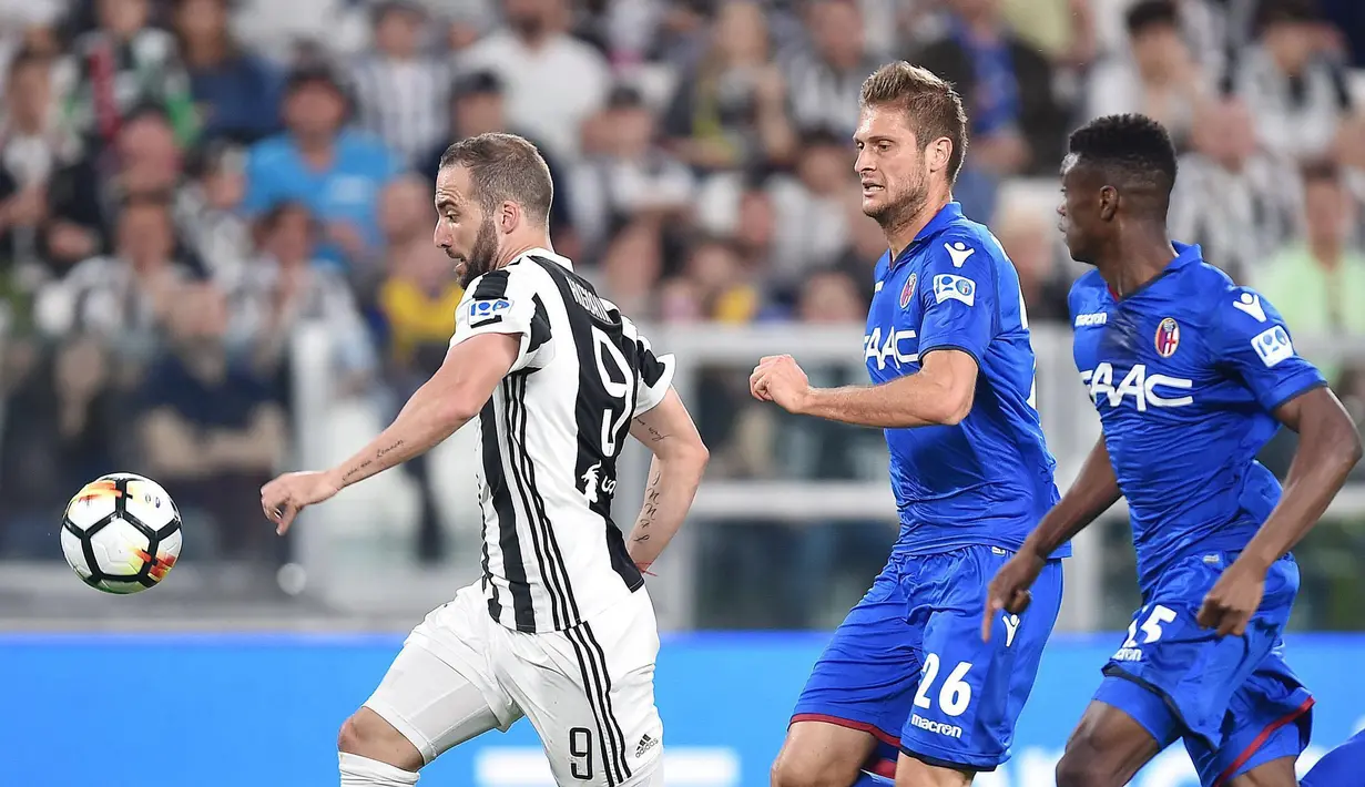 Aksi pemain Juventus, Gonzalo Higuain (kiri) melewati adangan dua pemain Bologna pada lanjutan Serie A di Allianz Stadium, Turin, (5/5/2018). Juventus menang 3-1. (Alessandro Di Marco/ANSA via AP)