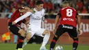 Gelandang Real Madrid, James Rodriguez, berusaha melewati kepungan pemain Real Mallorca pada laga La Liga Spanyol di Stadion Iberostar, Mallorca, Sabtu (19/10). Mallorca menang 1-0 atas Madrid. (AFP/Javier Reina)