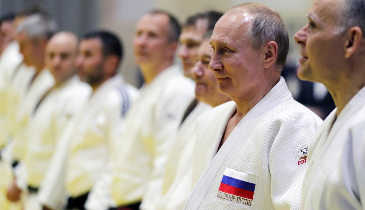 Presiden Rusia, Vladimir Putin mengambil bagian dalam sesi latihan judo bersama atlet nasional Rusia di Sochi, Kamis (14/2). Judo merupakan salah satu olahraga kegemaran Putin yang telah digeluti sejak masa muda. (Mikhail KLIMENTYEV/SPUTNIK/AFP)