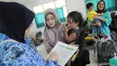 Istri anggota TNI menemani anaknya mengikuti vaksinasi ulang di Kantor Kesehatan Kopassus, Jakarta, Senin (18/7). Kopassus menggelar vaksinasi ulang terhadap anak prajurit yang terindikasi menjadi korban vaksin palsu. (Liputan6.com/Helmi Afandi)