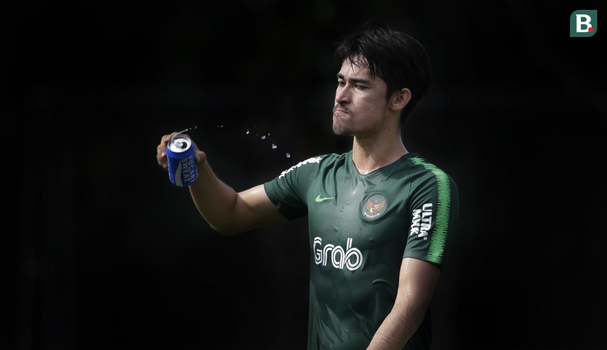 Pemain Timnas Indonesia, Gavin Kwan, melepas dahaga saat latihan di Lapangan ABC Senayan, Jakarta, Selasa (20/11). Latihan ini persiapan jelang laga Piala AFF 2018 melawan Filipina. (Bola.com/Vitalis Yogi Trisna)